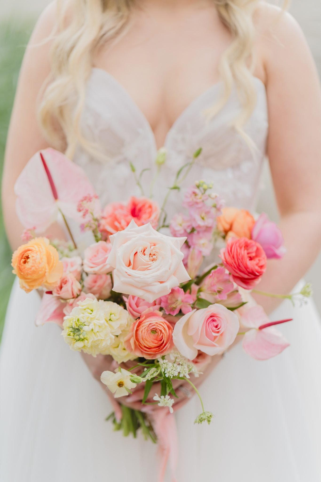 Bride holding a vibrant bouquet of pink, peach, and orange flowers at A Modern Floral Dream Wedding in Vancouver.
