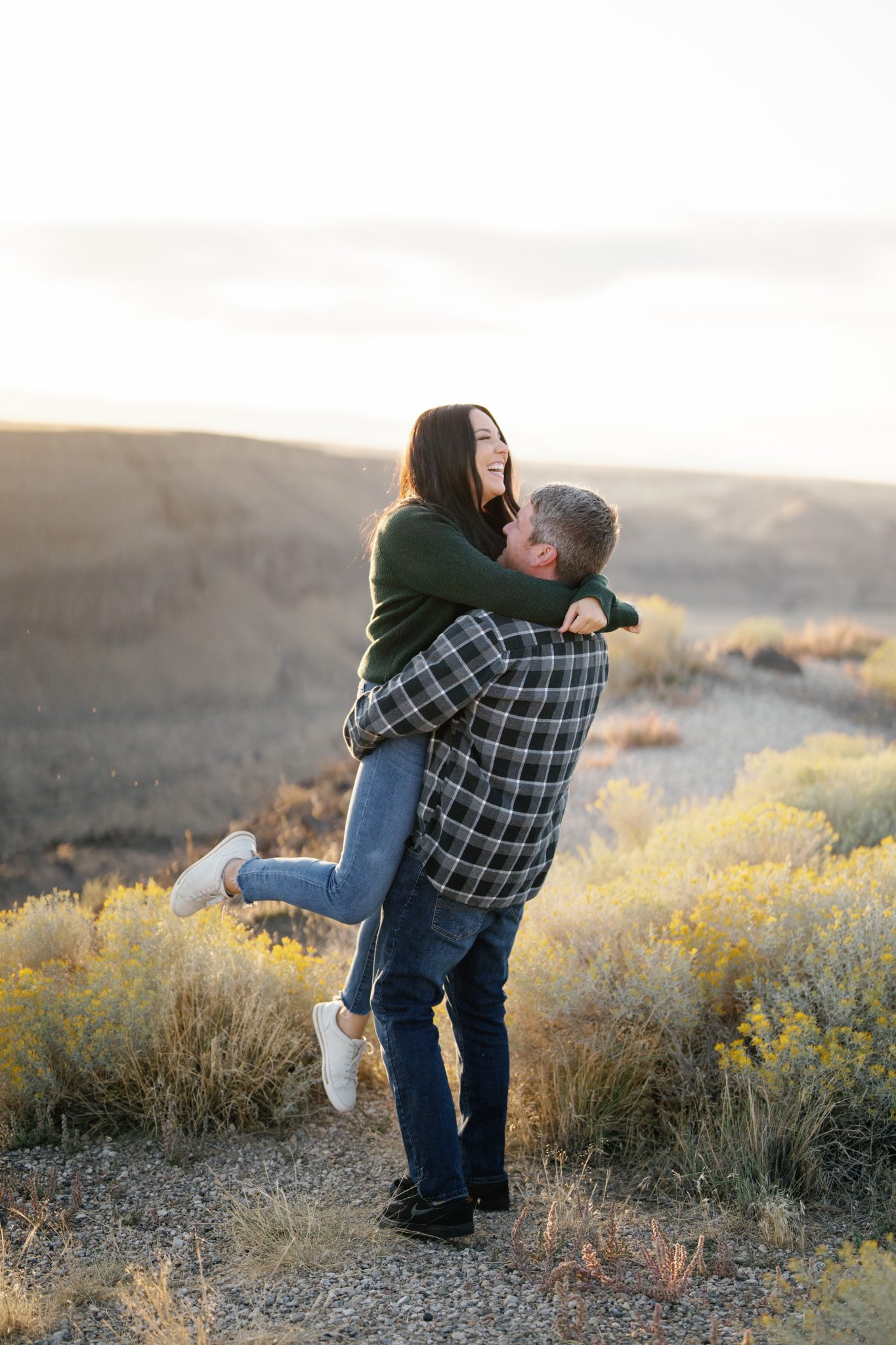 Couple sharing a joyful embrace during an Idaho engagement session at sunset