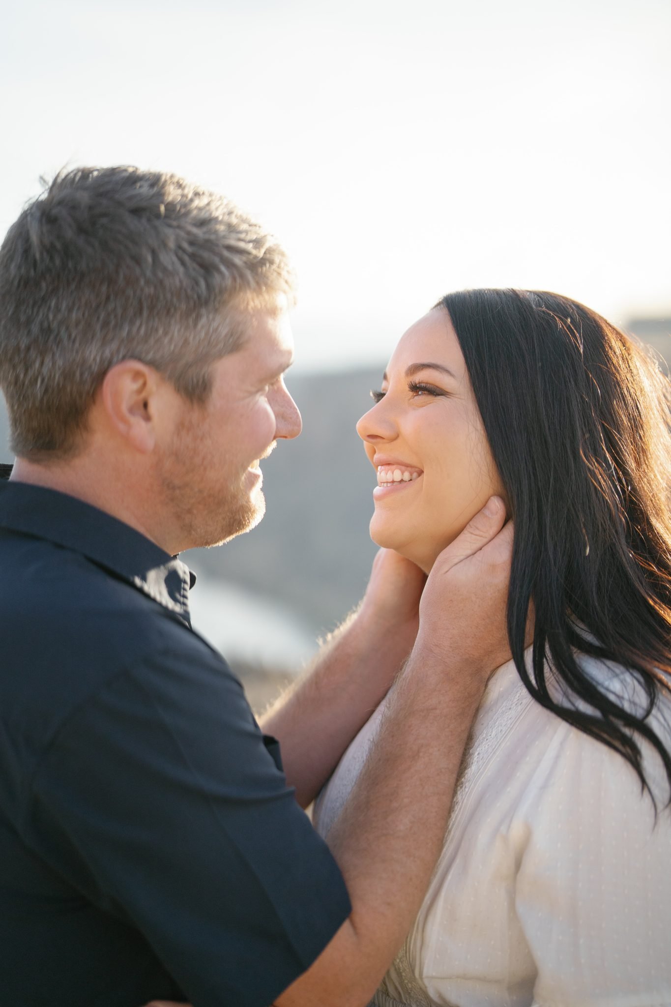 Couple smiling and looking into each other’s eyes in close-up during an Idaho engagement session