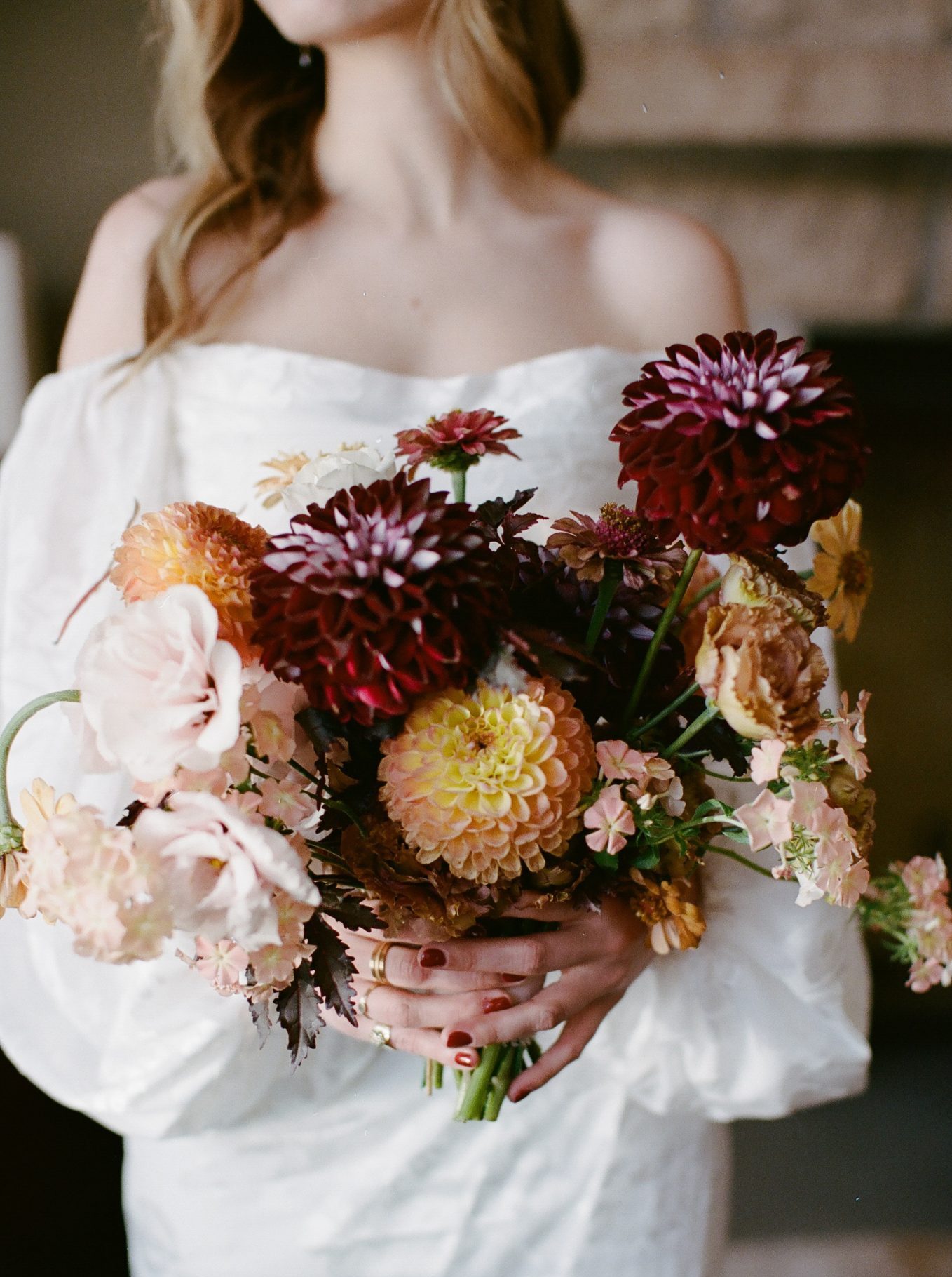 Close-up of the bride's vibrant bouquet featuring deep burgundy, soft peach, and blush flowers, perfect for a summer wedding in Crested Butte.