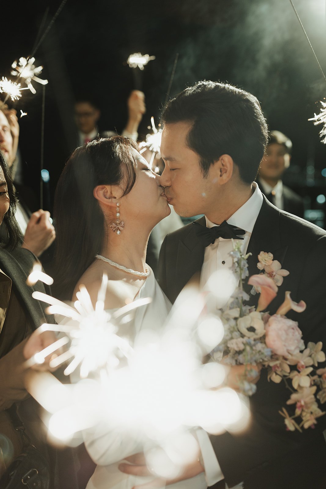 Bride and groom share a romantic kiss surrounded by sparklers at their British Columbia elegant wedding grand exit.