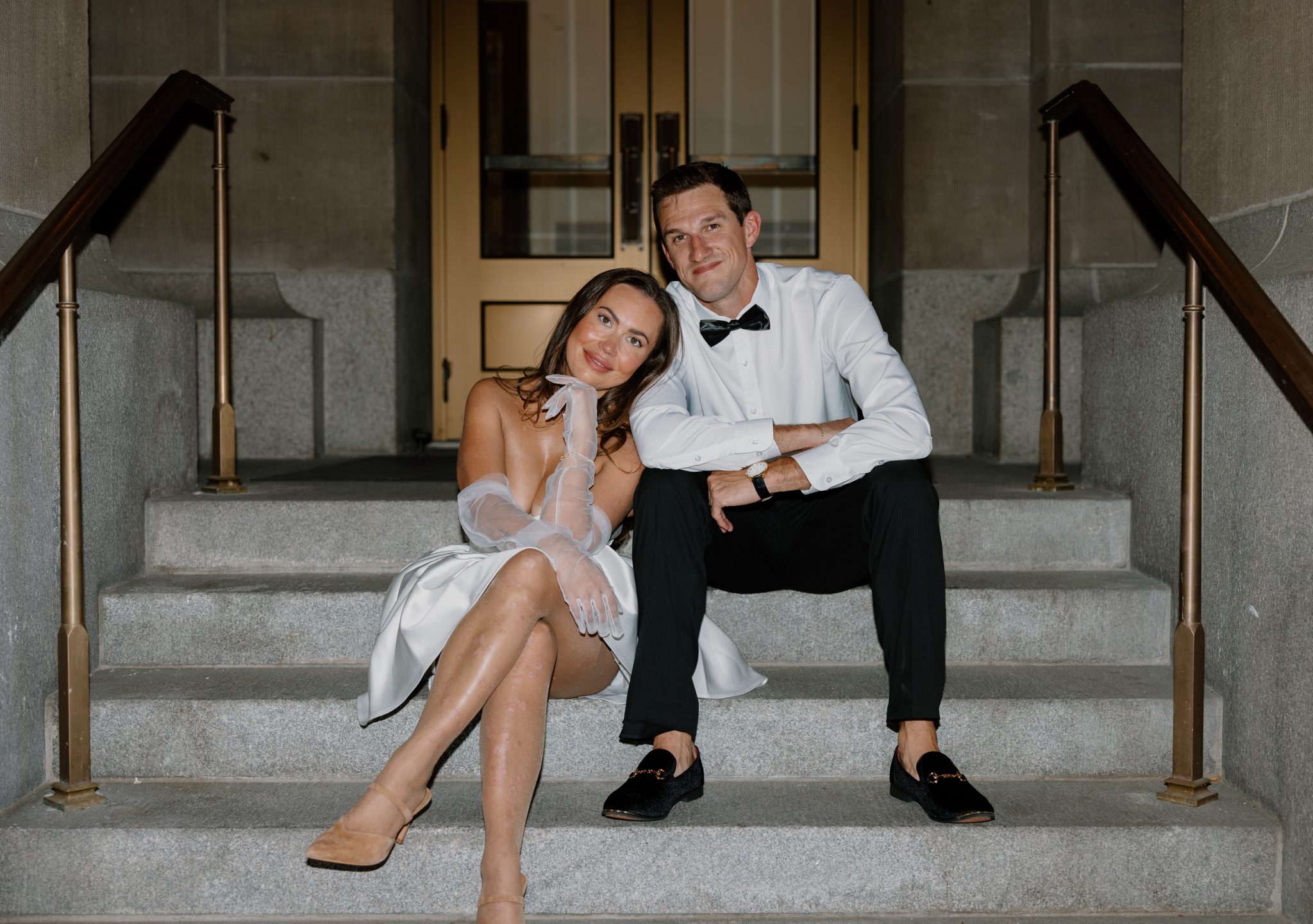 The couple sits together on stone steps, exuding relaxed elegance and charm during their classy Idaho anniversary session.