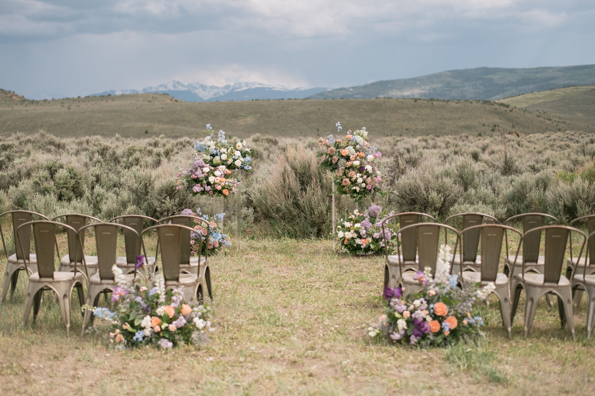 A breathtaking outdoor ceremony setup with floral arches and mountain views at a Four Seasons Resort Vail wedding.