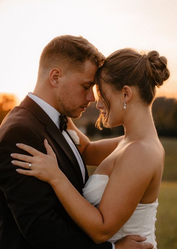 bride leaning forehead against her husband's with Romantic Bun