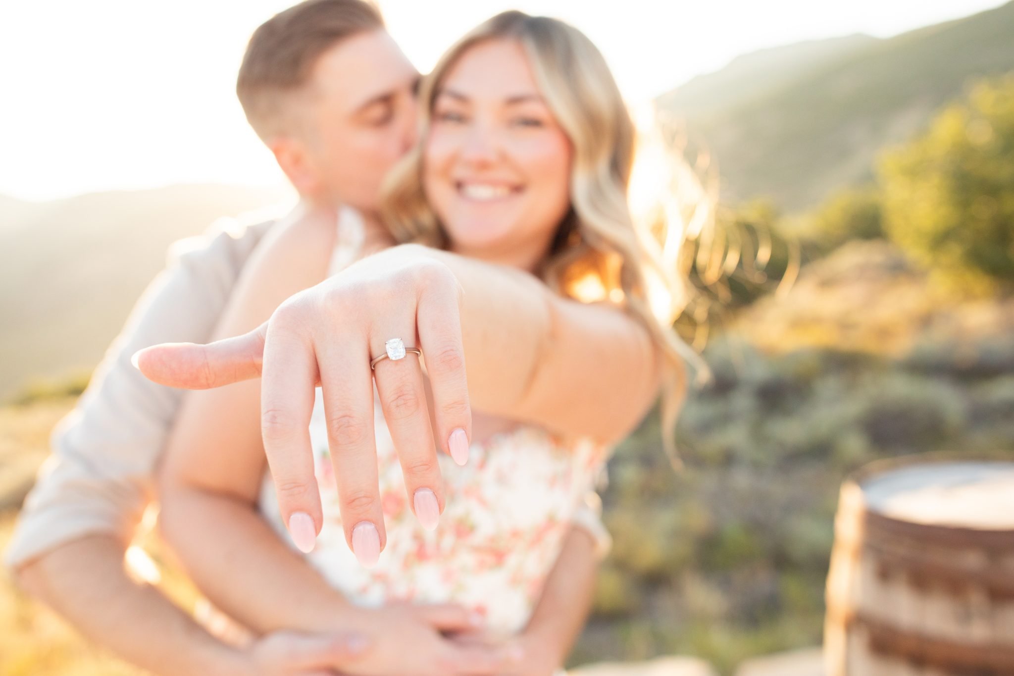 A close-up of the engagement ring as the couple celebrates their Utah wedding proposal with a warm embrace and glowing smiles.
