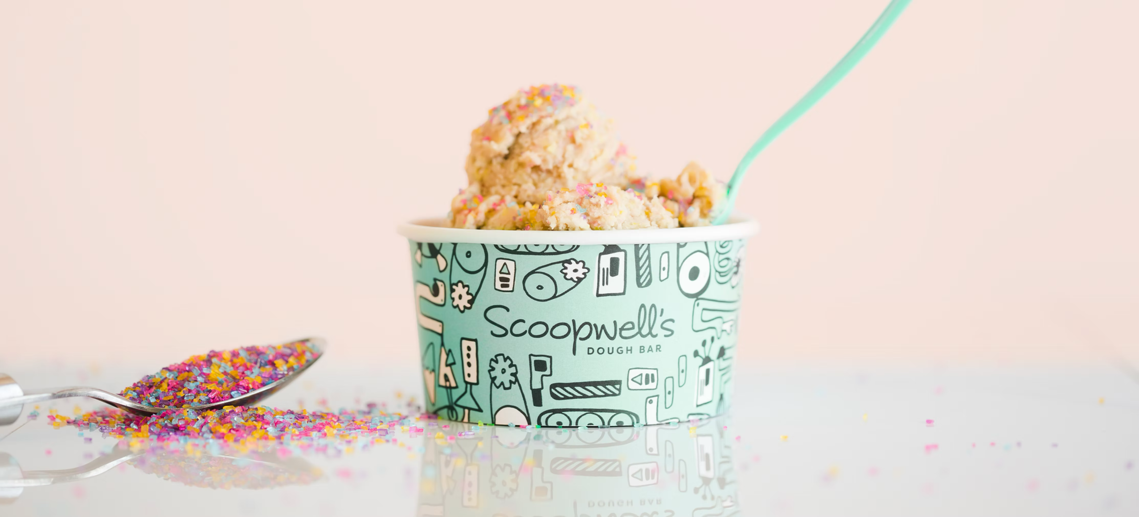 Cups of edible cookie dough from Scoopwells Dough Bar in various flavors, a fun alternative to traditional wedding desserts.
