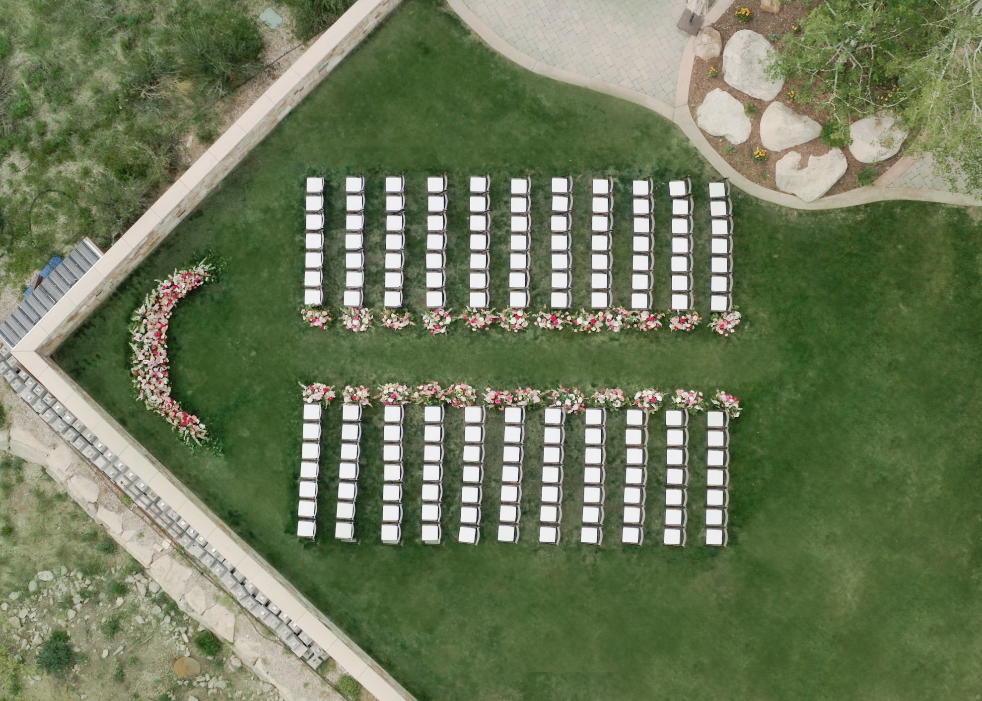 Aerial view of an elegant outdoor ceremony setup with rows of white chairs and vibrant floral arrangements at The St. Regis Deer Valley Wedding.