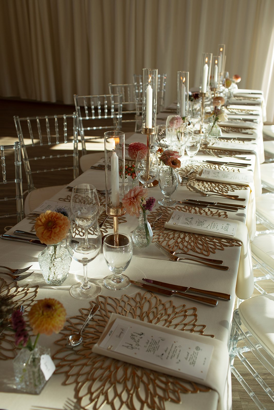 Elegant reception table setup with candlelight and floral accents in soft autumn hues for a Fall Alberta wedding.