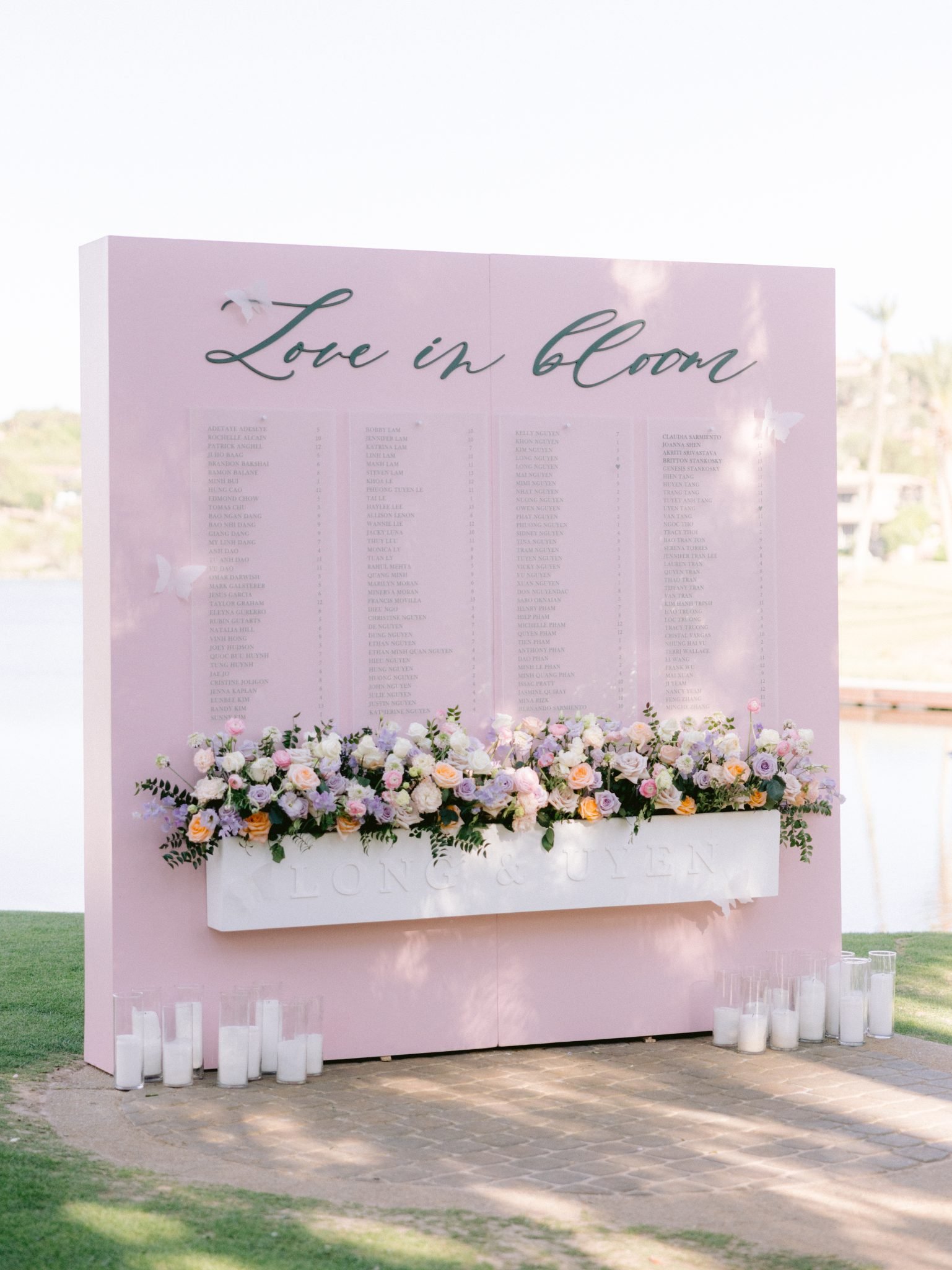 Elegant seating chart at a luxury Las Vegas wedding Rocky Mountain Bride + Mountain West – A blush pink wedding seating chart adorned with fresh flowers and candles, welcoming guests with a romantic touch.
