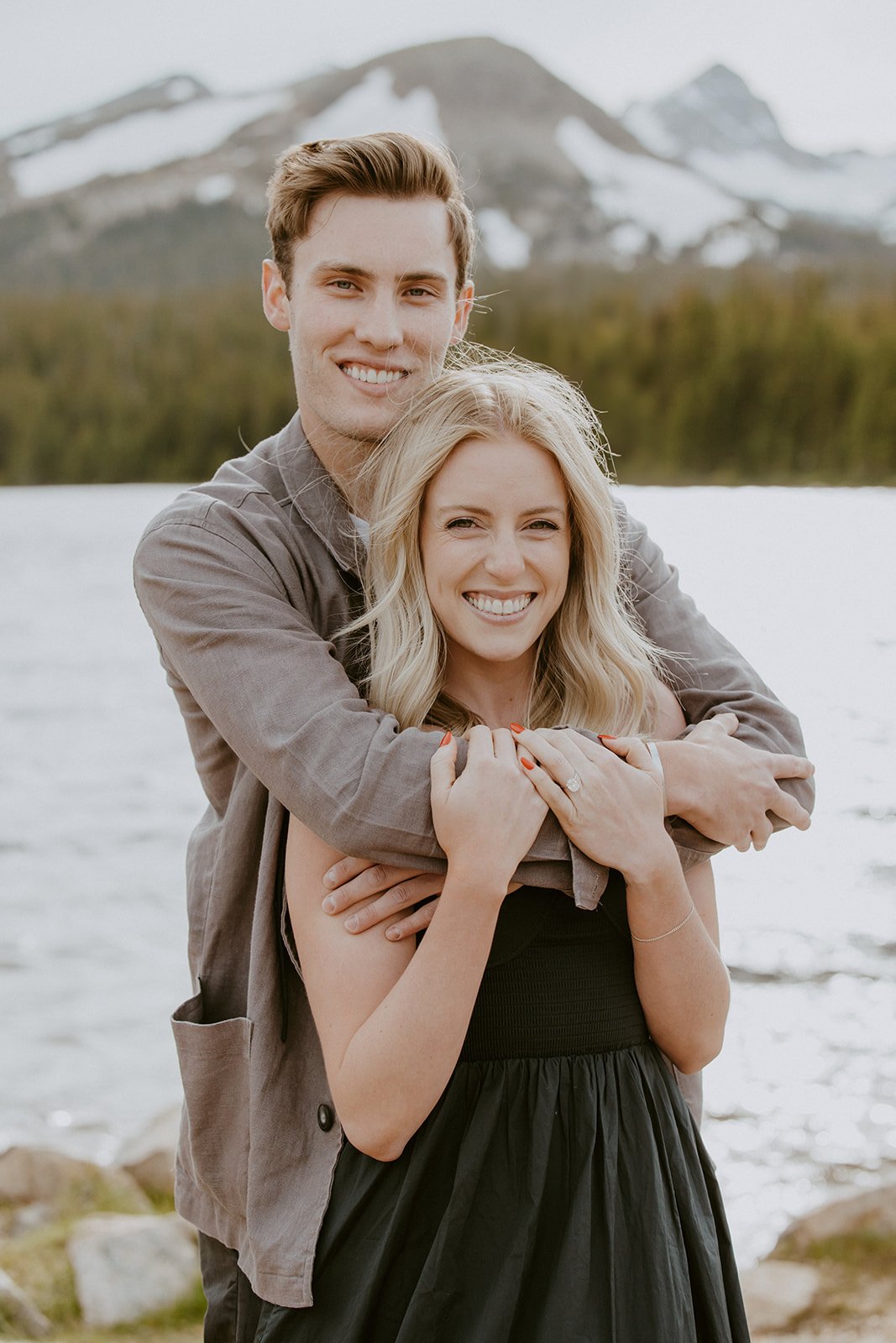 The newly engaged couple shares a joyful embrace, with the mountains and lake creating a stunning backdrop for their Brainard Lake Proposal.