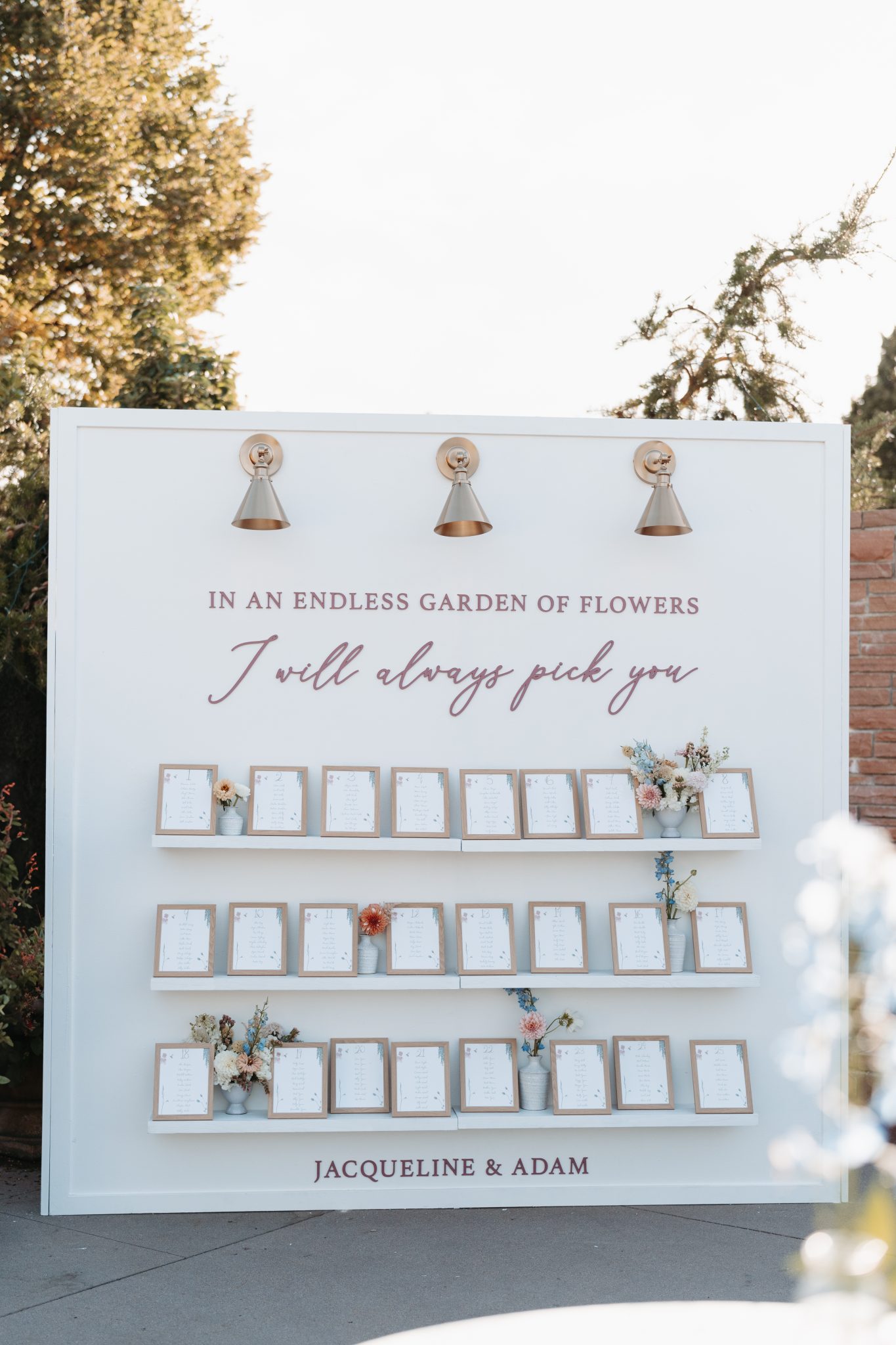 Unique escort card display with the phrase "In an endless garden of flowers, I will always pick you," set at a Denver Botanic Gardens wedding.