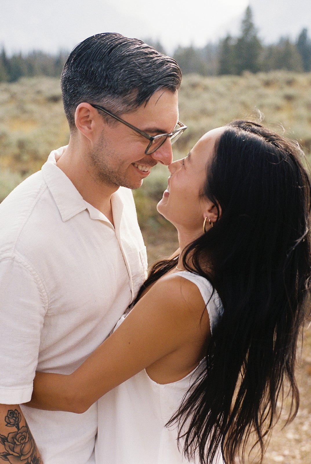 The couple gazes into each other’s eyes with soft smiles, the golden light highlighting their happiness during their National Park Day Before Wedding Session.