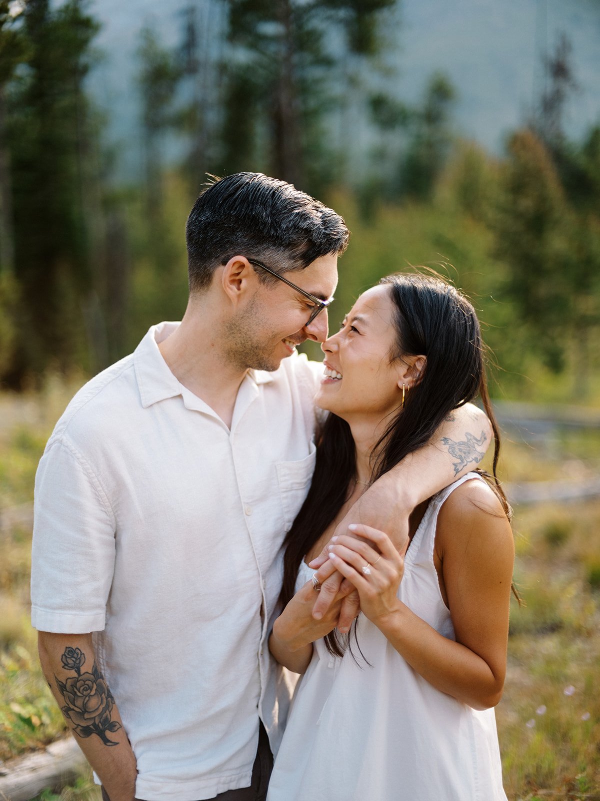 The bride-to-be wraps her arms around her fiancé as they share a joyful moment surrounded by the natural beauty of their National Park Day Before Wedding Session.