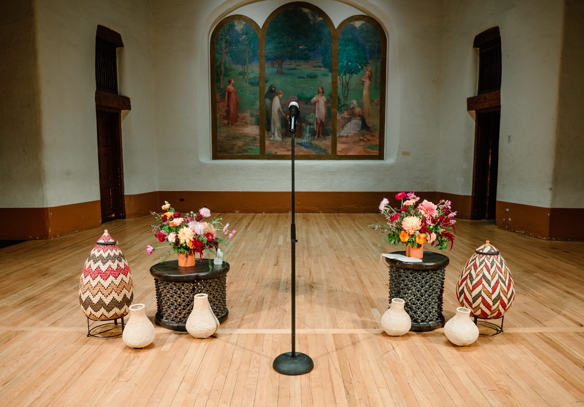 A rustic outdoor reception setup with wooden tables, fresh florals, and hanging red chile ristras, embracing the Southwestern charm of this New Mexico Museum of Art summer wedding rocky mountain bride.