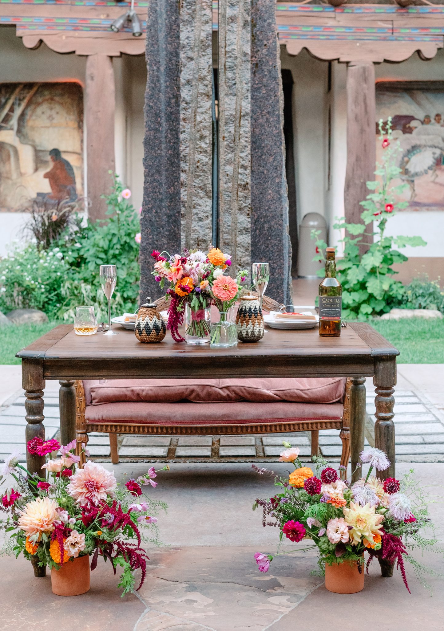 The couple stands in the courtyard surrounded by adobe architecture, wooden balconies, and hanging red chiles, embodying the cultural beauty of this New Mexico Museum of Art summer wedding rocky mountain bride.
