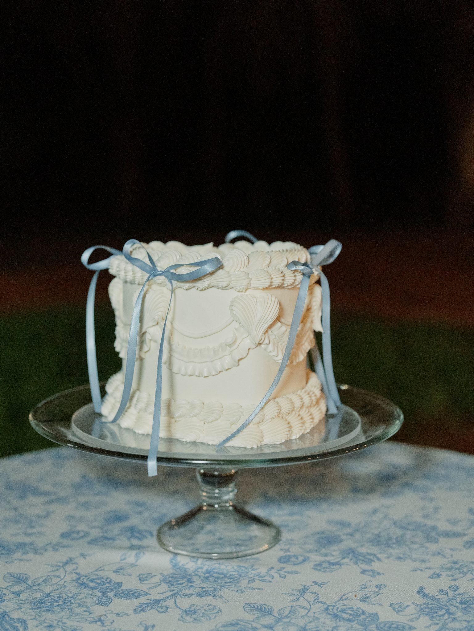 Whimsical vintage cake with piped white frosting and delicate blue ribbon accents at a Private Property Saje Photography Arizona Wedding.