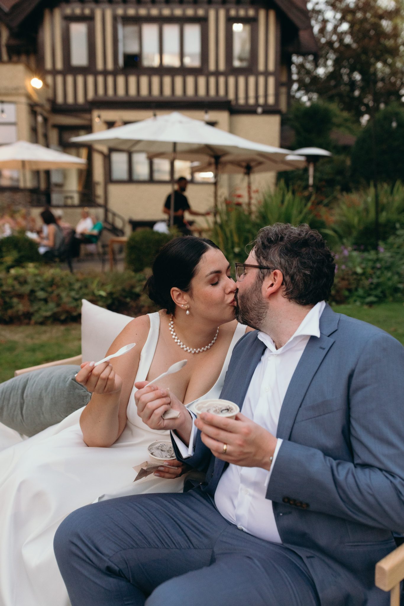Bride and groom sharing a kiss while enjoying ice cream during their Vibrant British Columbia Tented Wedding reception