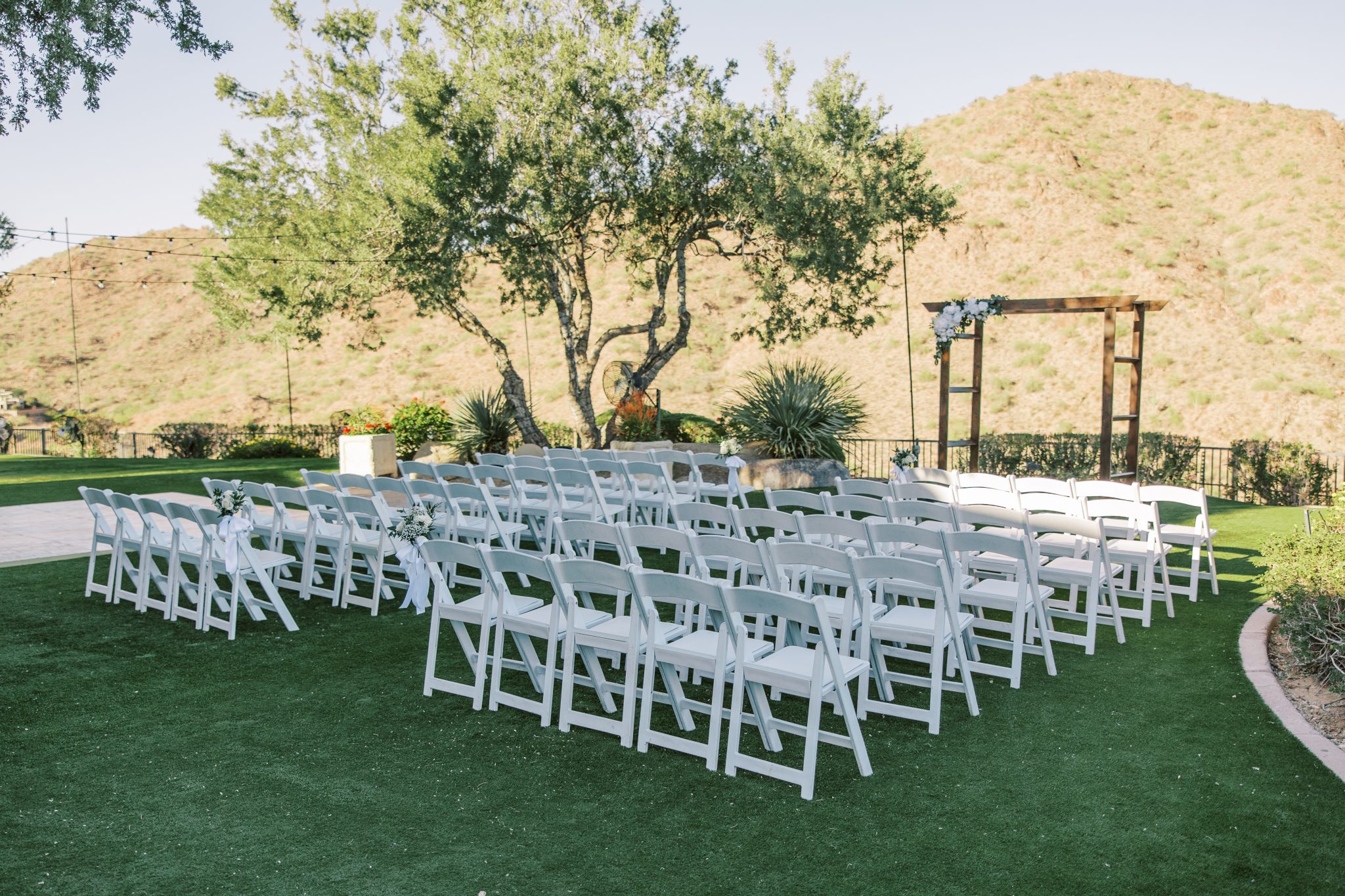 Outdoor ceremony setup with white chairs and scenic mountain views at Adero Scottsdale Resort white and black wedding.