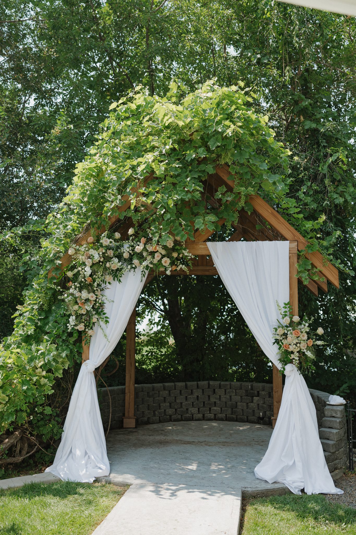 Rustic wooden arbor covered in greenery and floral arrangements prepared for an idaho wedding rocky mountain bride ceremony.