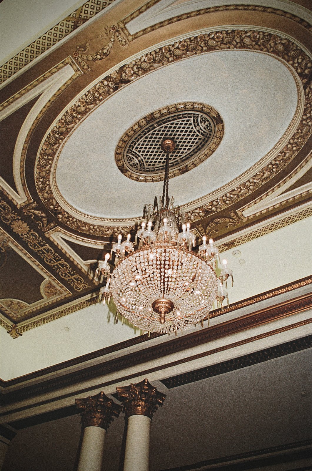 Ornate ceiling with detailed molding and crystal chandelier at Brix and Mortar wedding rocky mountain bride venue.