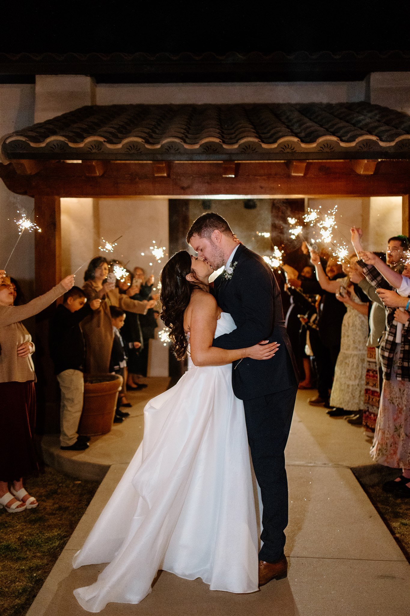 Romantic sparkler exit with bride and groom kissing under the lights at a Los Portales New Mexico spring wedding rocky mountain bride.