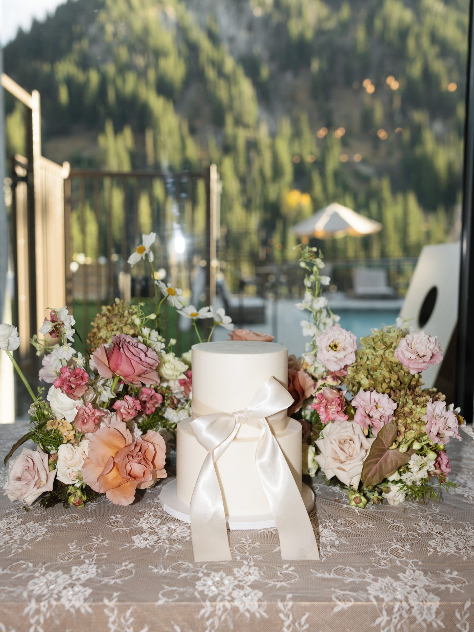 Elegant two-tier wedding cake with satin bow surrounded by autumn florals at a Snowpine Lodge fall wedding in utah rocky mountain bride.