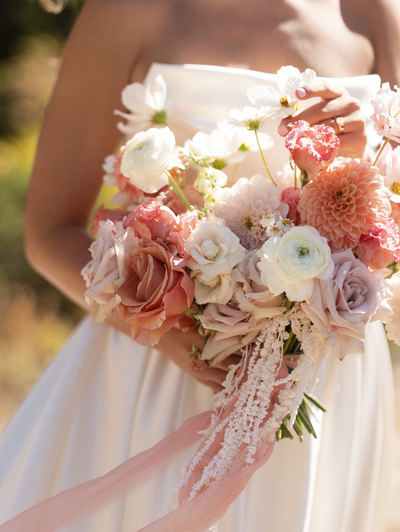 Close-up of a romantic bouquet with soft peach, blush, and white florals held by the bride at a Snowpine Lodge fall wedding in utah rocky mountain bride.