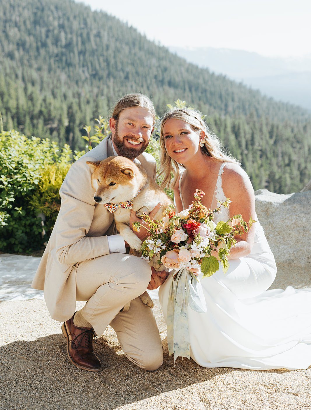 Bride and groom pose with their Shiba Inu, holding a colorful bouquet during a Tahoe Blue Estate summer wedding rocky mountain bride.