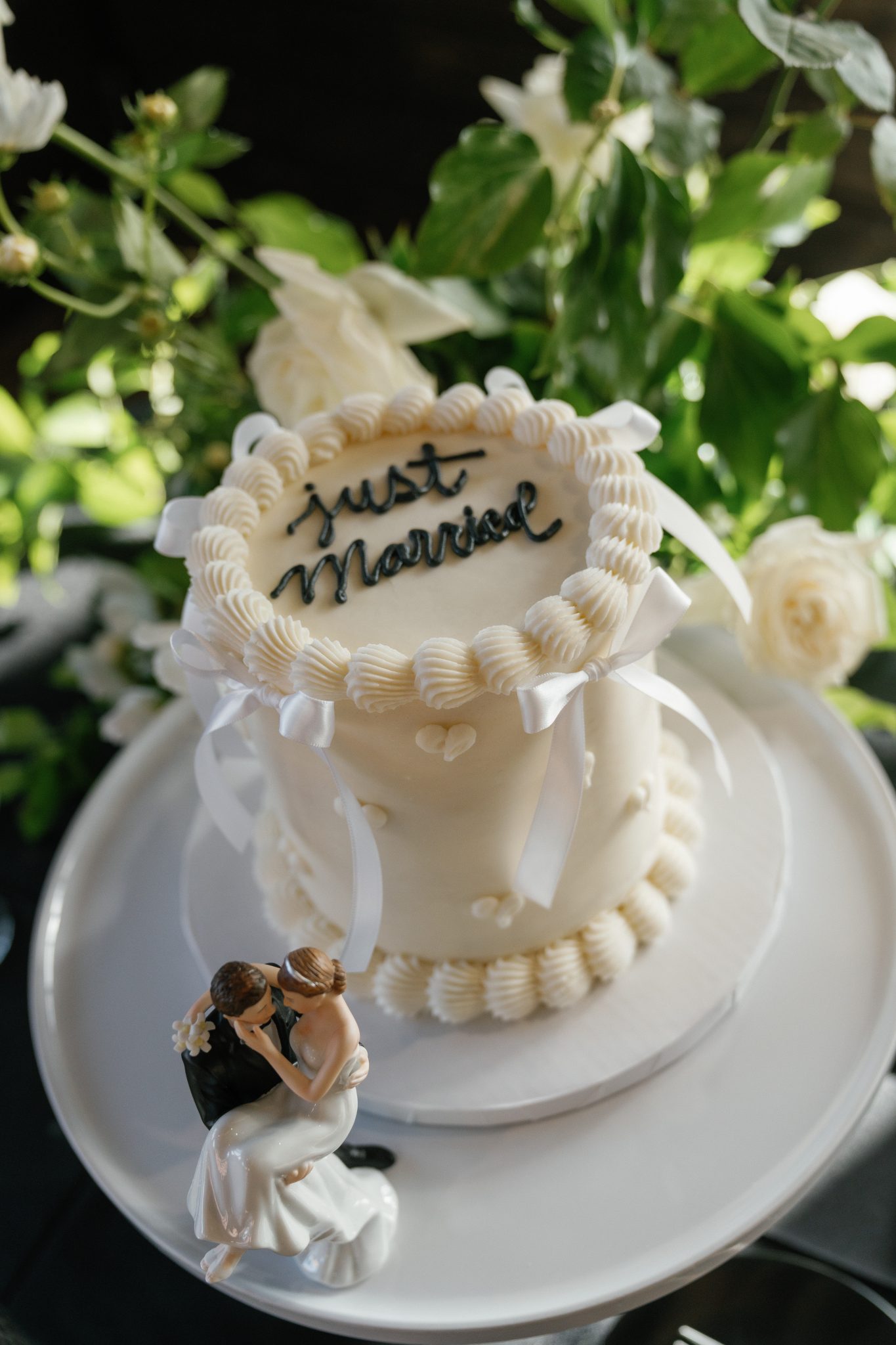 Classic white wedding cake with piped detailing and figurine topper at a park city utah wedding rocky mountain bride reception.