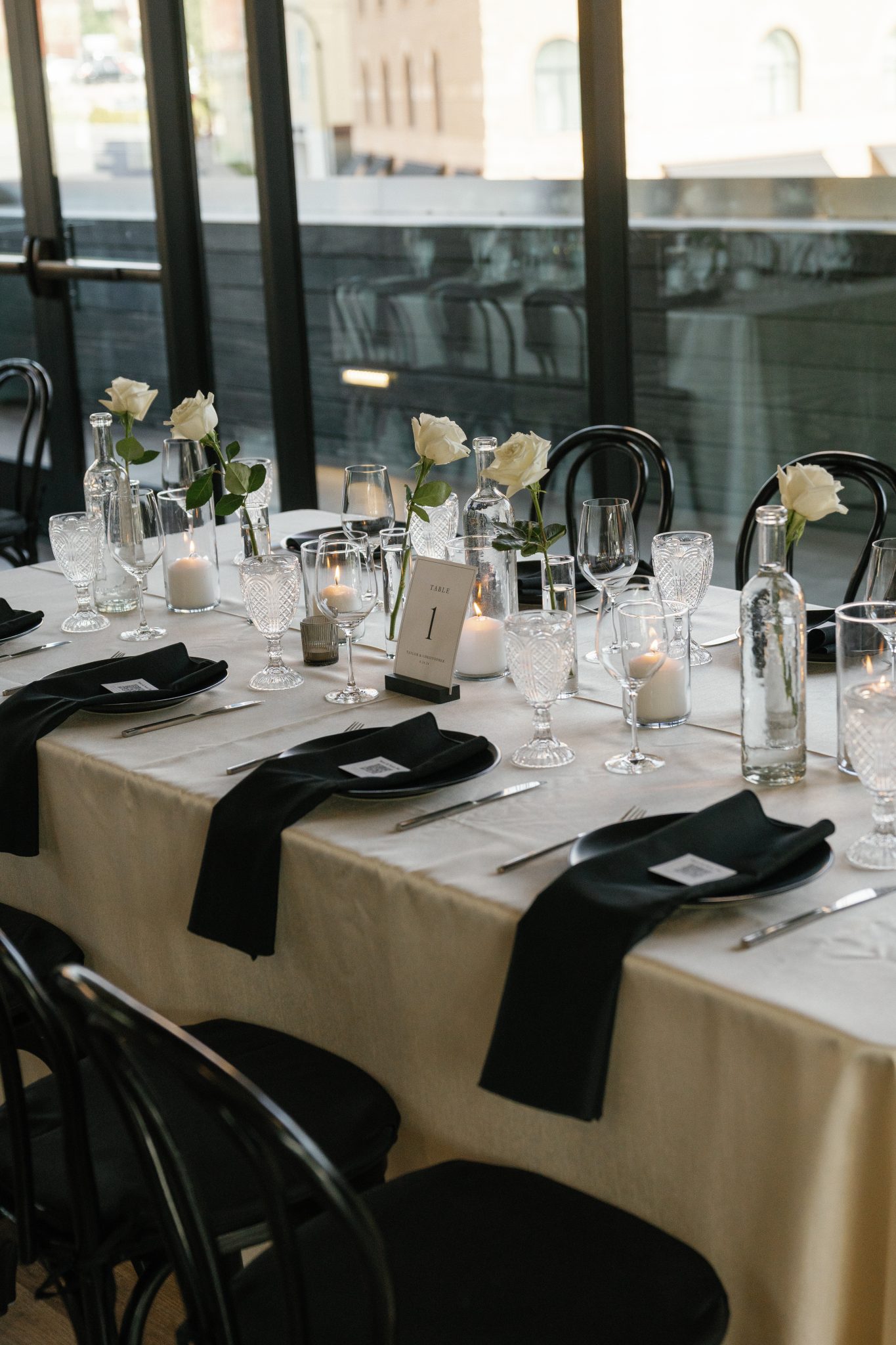 Minimal black-and-white reception tablescape with single-stem roses and crystal glassware at a park city utah wedding rocky mountain bride.