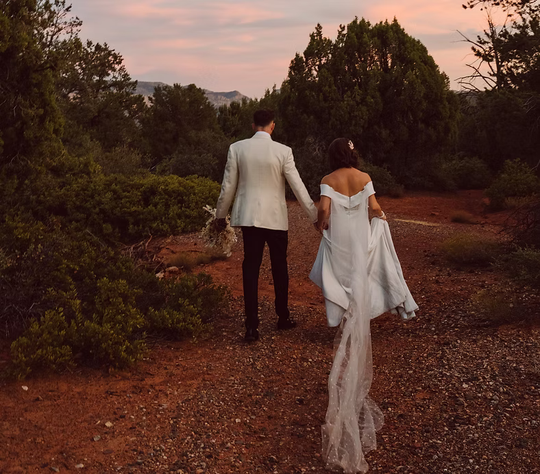 Bride and groom walking through the red rocks at Eagle Dancer Sedona wedding venue