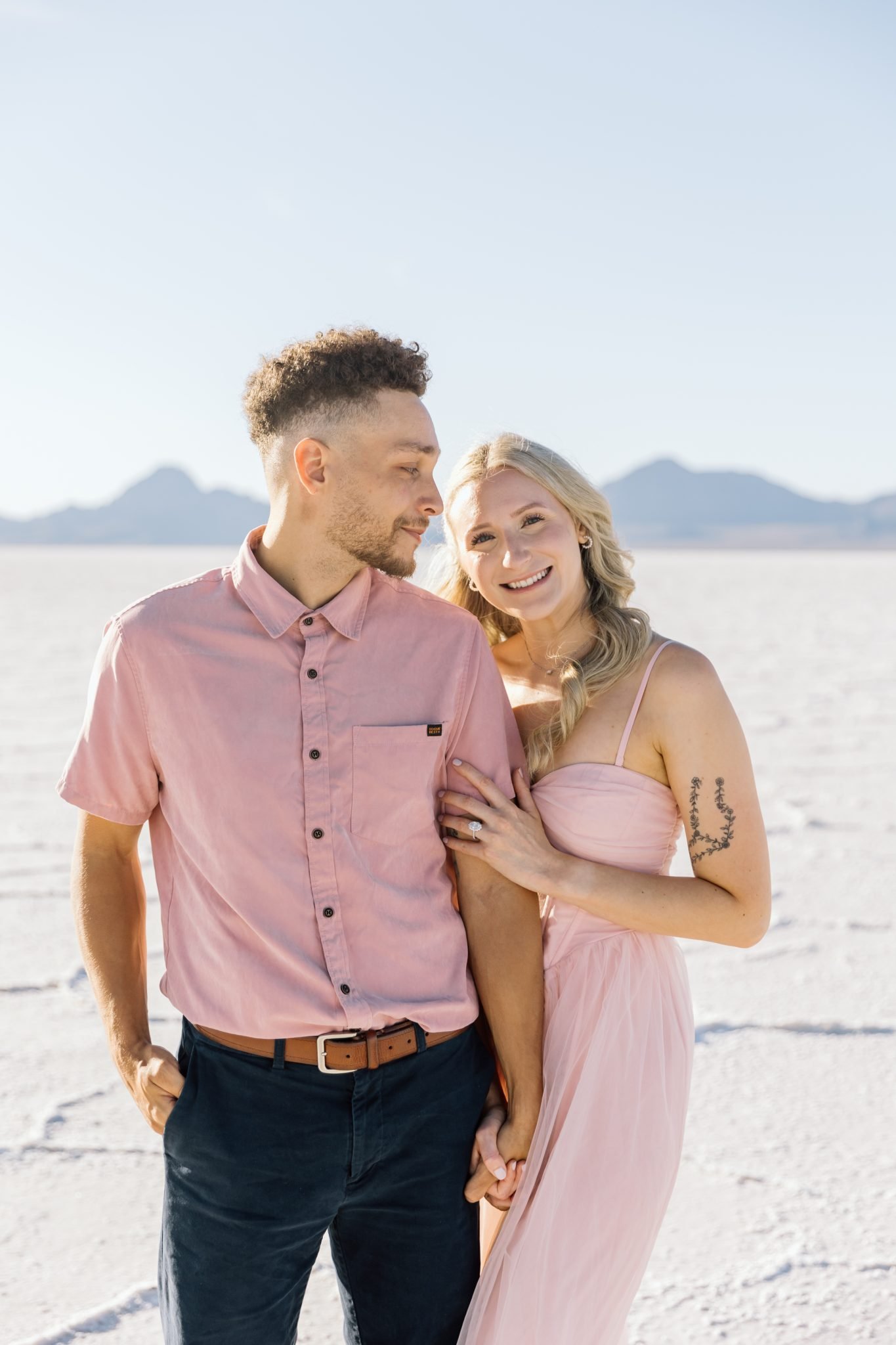 Couple smiling and holding hands during a Bonneville Salt Flats engagement session Niki Baldwin Photography rocky mountain bride.