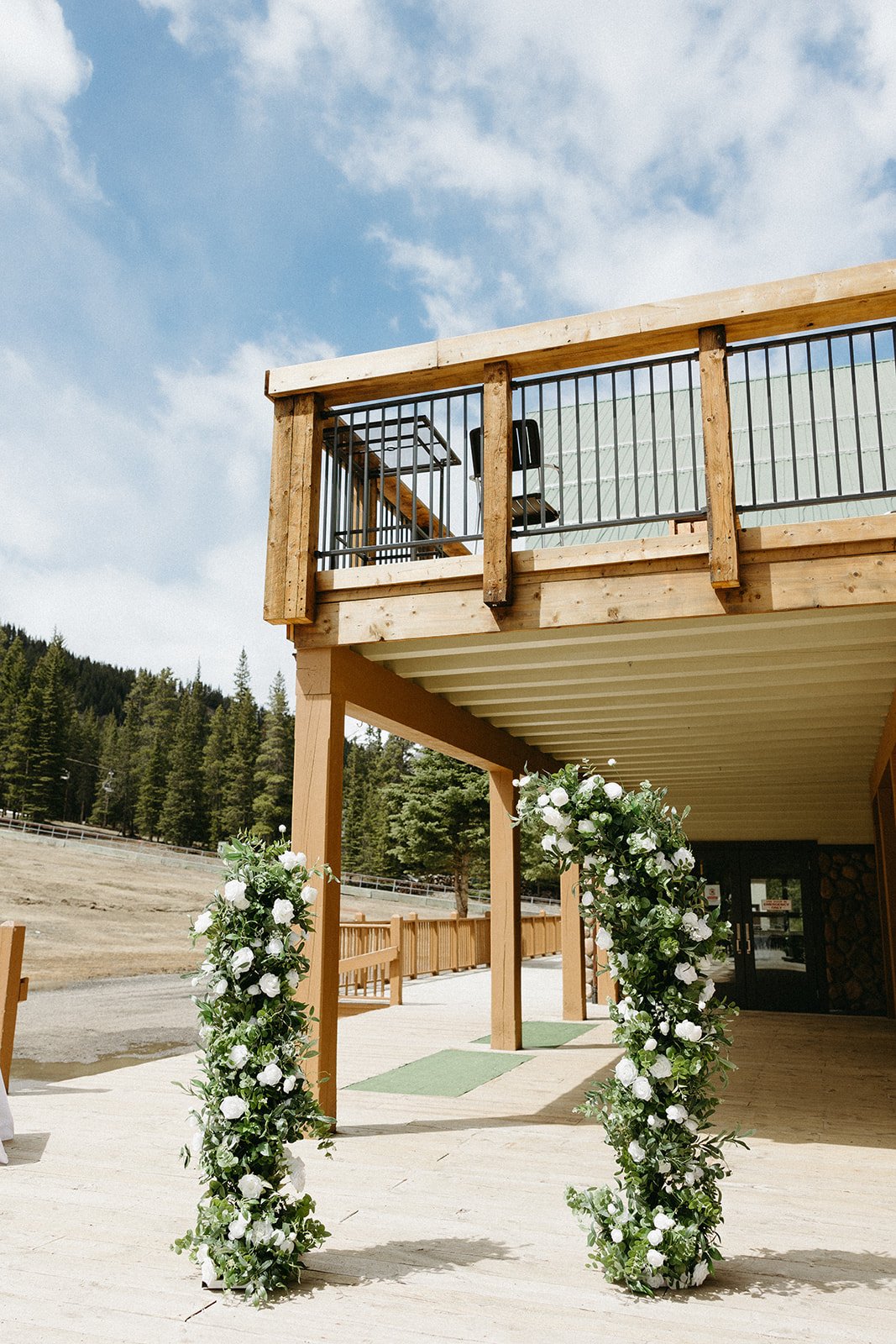 Floral ceremony pillars outside a rustic lodge at a Mt. Norquay Ski Resort wedding rocky mountain bride event.