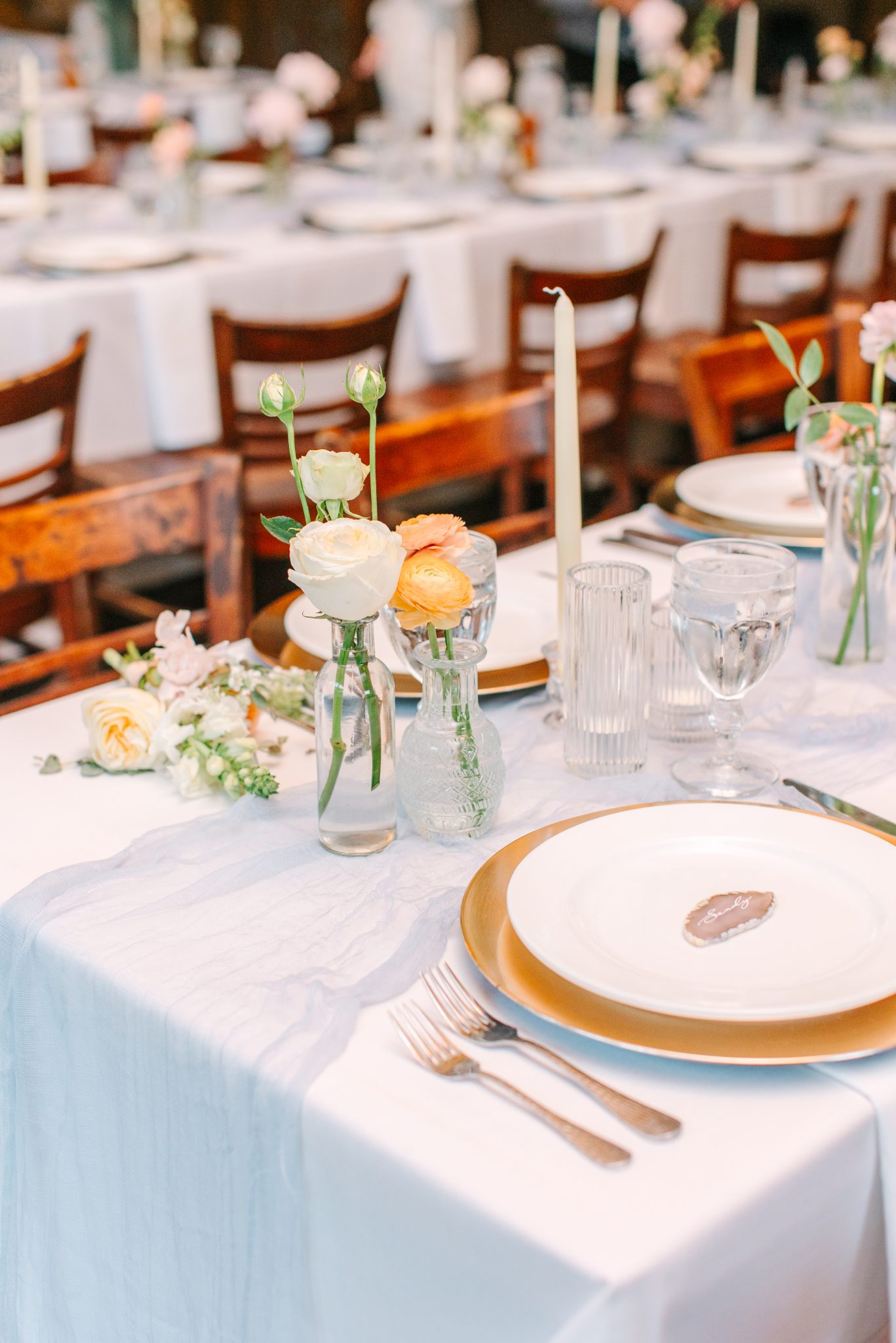 Elegant reception table at a Purgatory Resort winter wedding rocky mountain bride featuring delicate florals, gold chargers, and romantic candlelight.