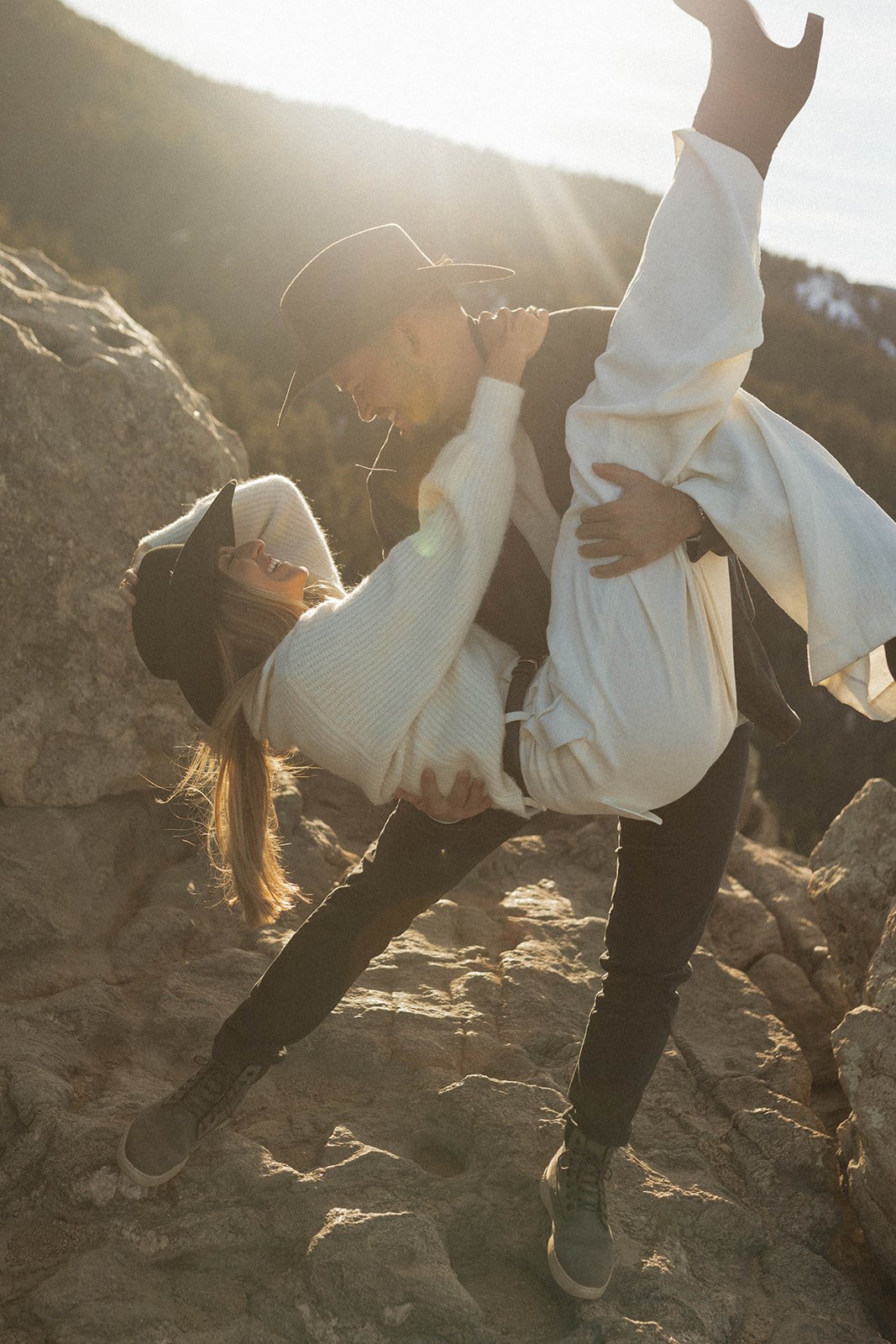Playful and romantic moment as the groom lifts the bride in laughter atop scenic rocks during their S Lynne Photography Boulder Colorado engagement session rocky mountain bride.