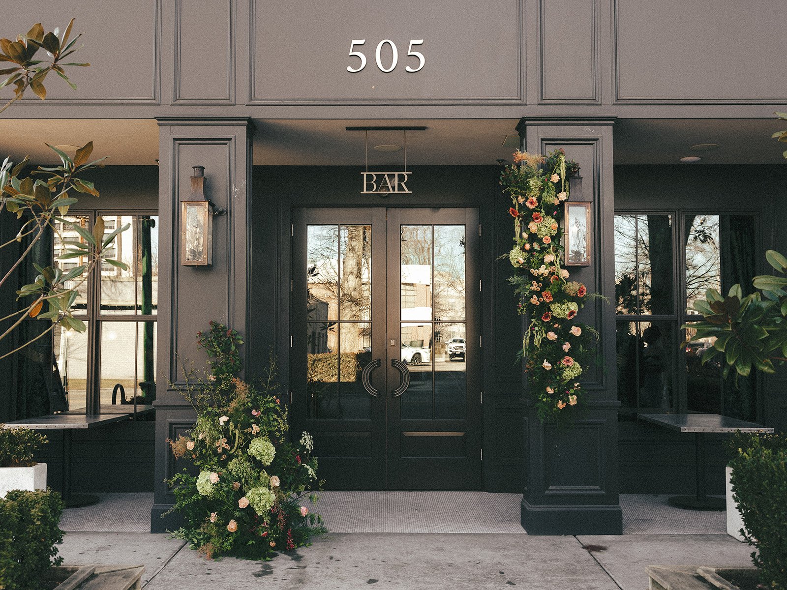 Elegant entrance of The Lively in downtown Boise, Idaho adorned with lush florals for an editorial bride modern tablescape chic wedding the lively downtown boise idaho floral heavy intimate reception dinner pink film elopement.