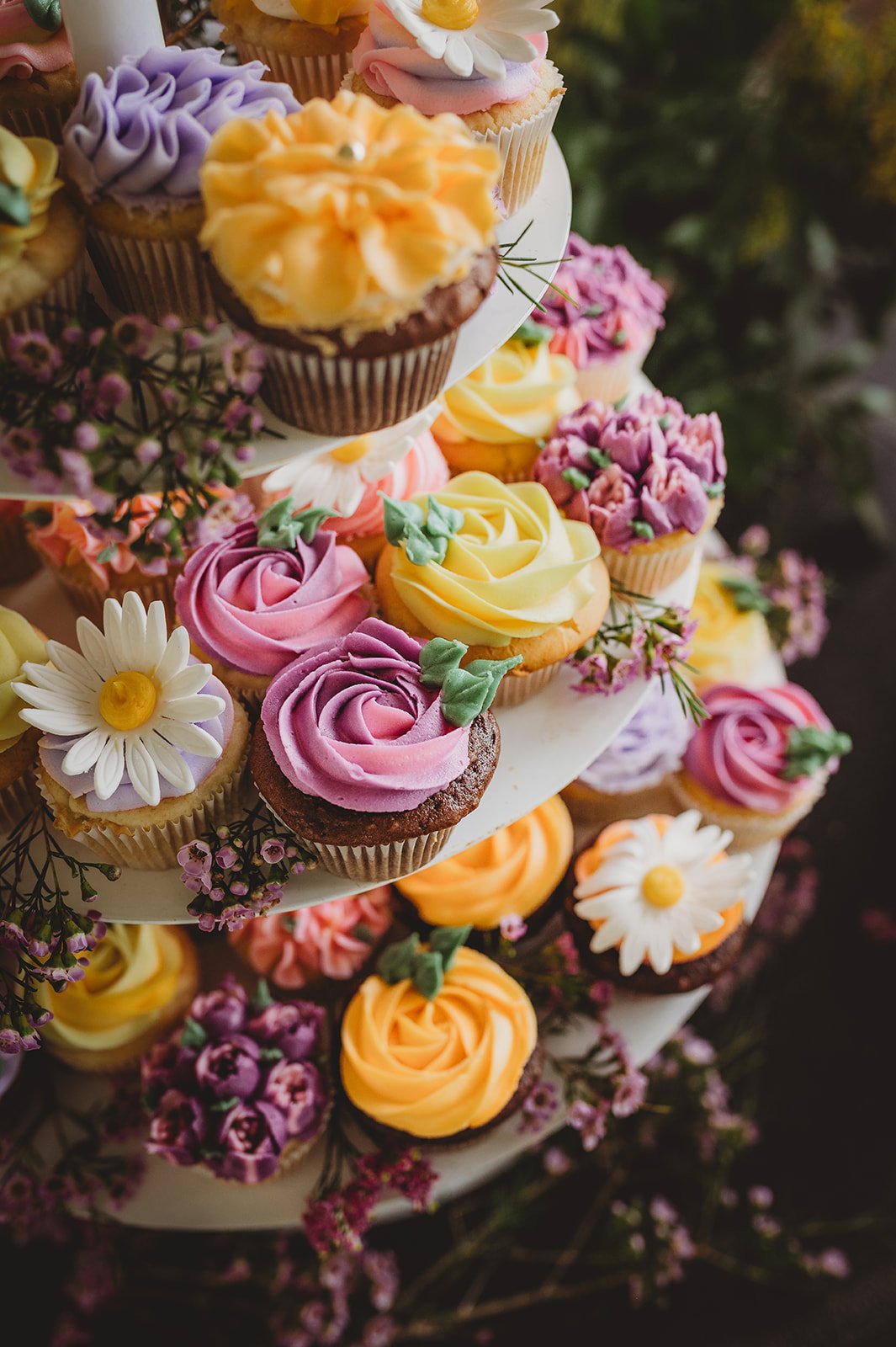 Elegant floral cupcakes displayed on a tiered stand for dessert at a private estate wedding in British Columbia Rocky Mountain Bride.
