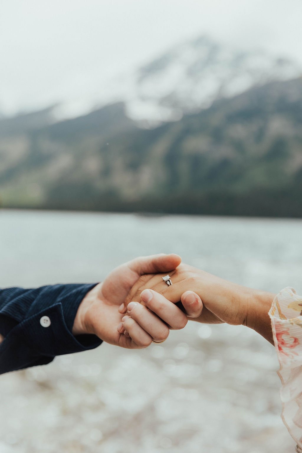 Close-up of couple holding hands with engagement ring at Grand Teton National Park engagement session with Ashlyn French Photography rocky mountain bride