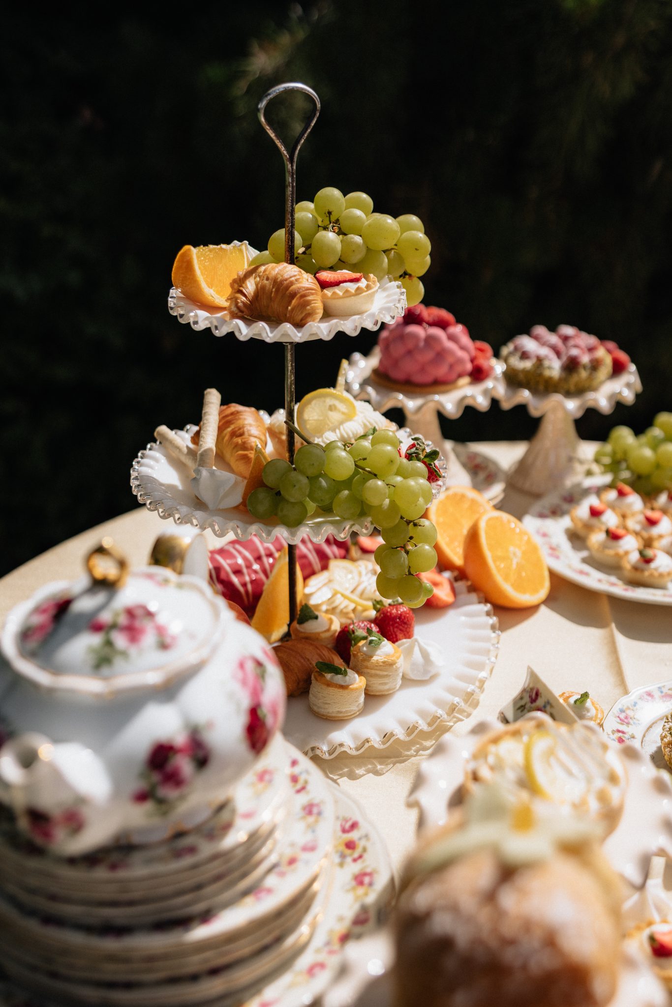 Tiered dessert display featuring grapes, oranges, pastries, and elegant floral china at an outdoor reception for The Northampton House and Jenny Pearl Photography wedding inspiration rocky mountain bride.