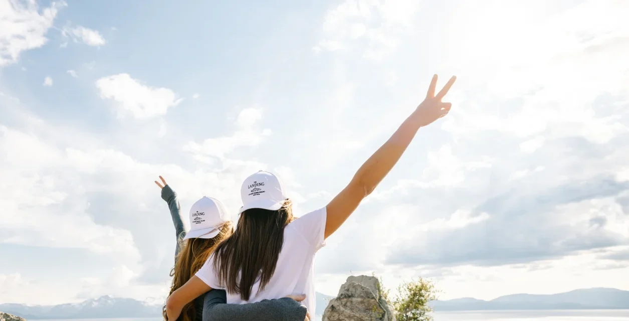  friends looking at lake tahoe with backwards hats