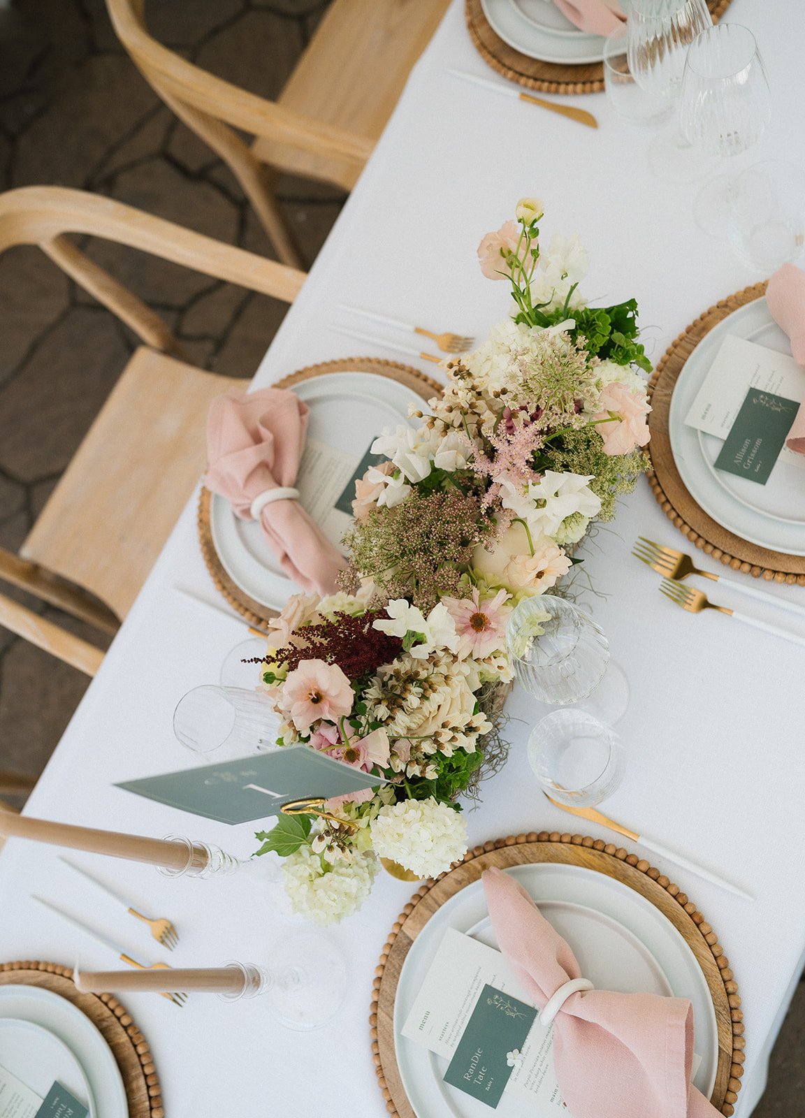 Elegant table setting with blush napkins, wooden chargers, and garden-inspired centerpiece at a boise idaho private home intimate spring wedding emily battles photography.